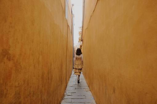 walk lifestyles one person outdoors men walking women woman;yellow dress;corridor;narrow