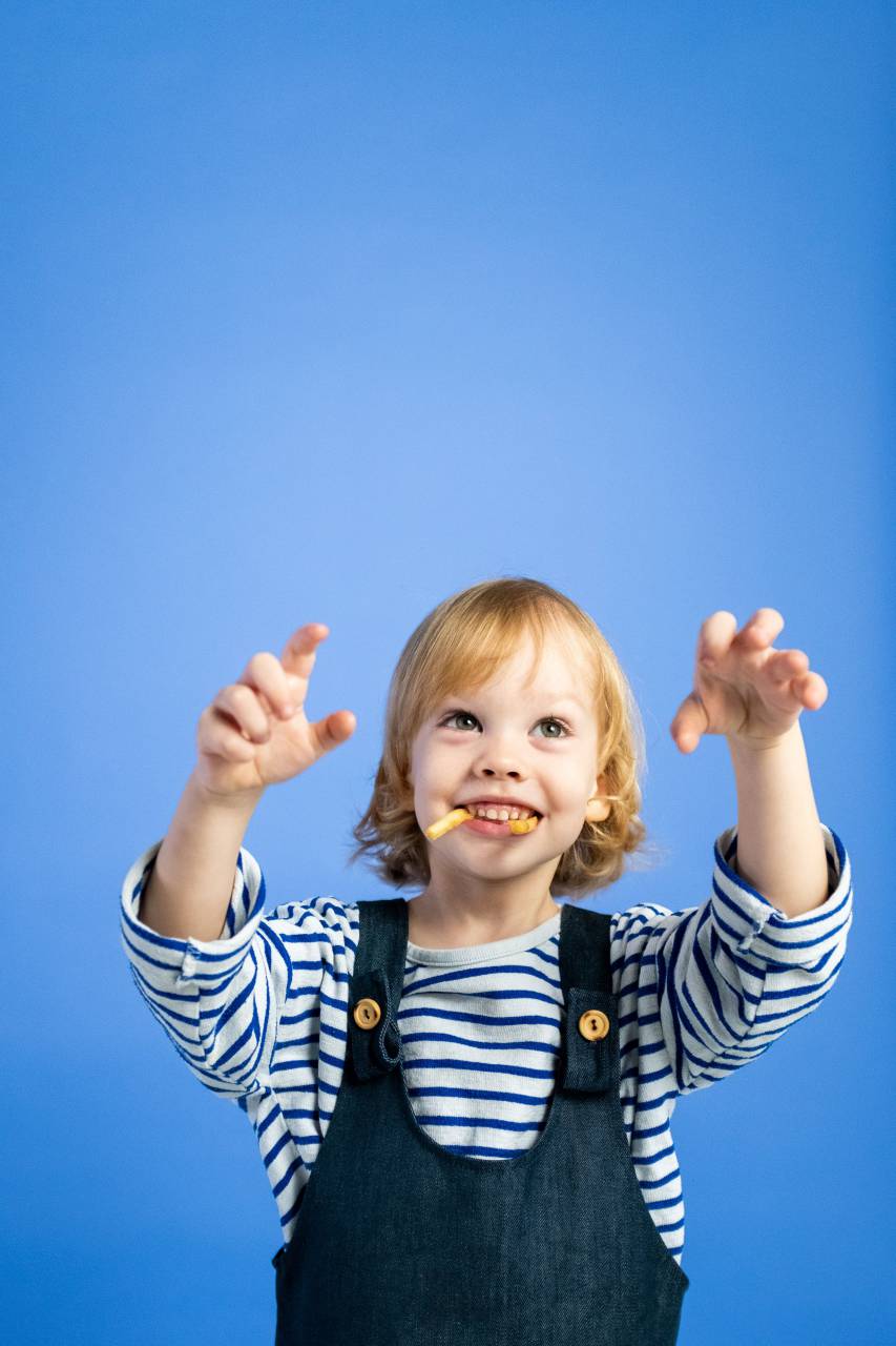 child;food;tungs,child,cute,cheerful,caucasian ethnicity,smiling,happiness,childhood,one person,boys,fun,blue,small,portrait,joy,blond hair,lifestyles,girls,looking,toddler,baby,blue background,outdoors,playful,studio shot,innocence,playing, 