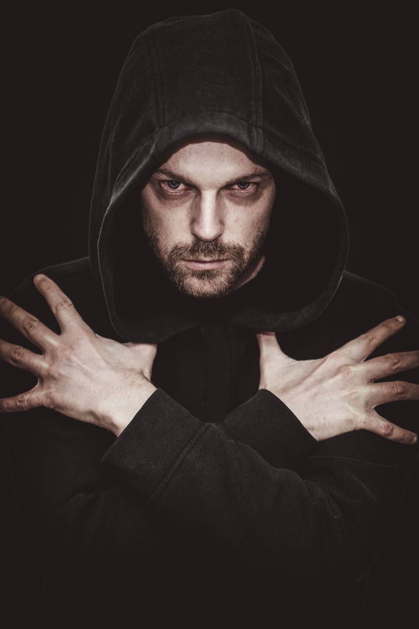 vampire,men,one person,adult,males,portrait,caucasian ethnicity,young adult,looking at camera,hood,clothing,beard,studio shot,black background,looking,human face,dark,serious, 