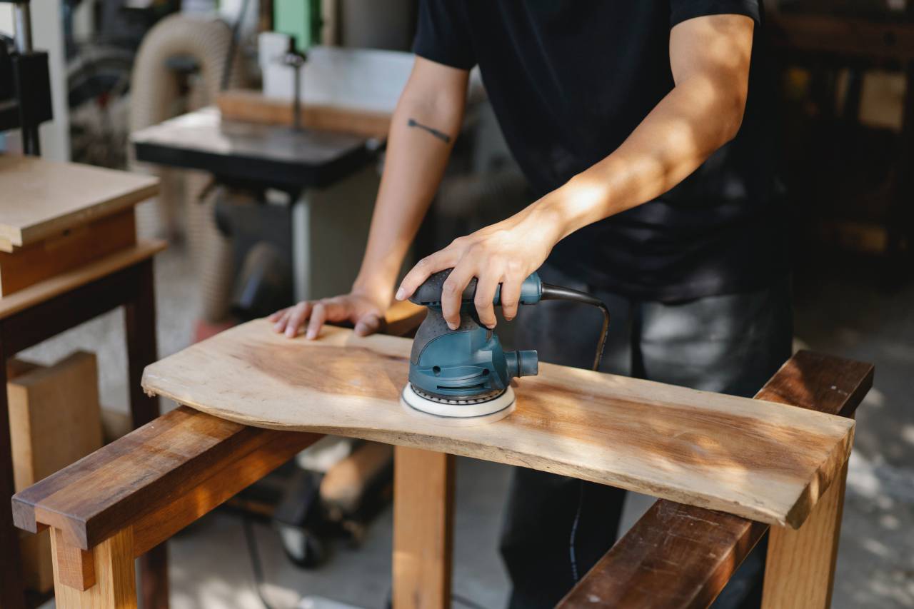 Charpenter;sanding,working,carpenter,workshop,work tool,carpentry,one person,men,occupation,craftsperson,craft,industry,wood,material,indoors,human hand,adult,equipment,plank,skill,table,construction industry,close-up,cutting,caucasian ethnicity,electric saw,timber,women, 