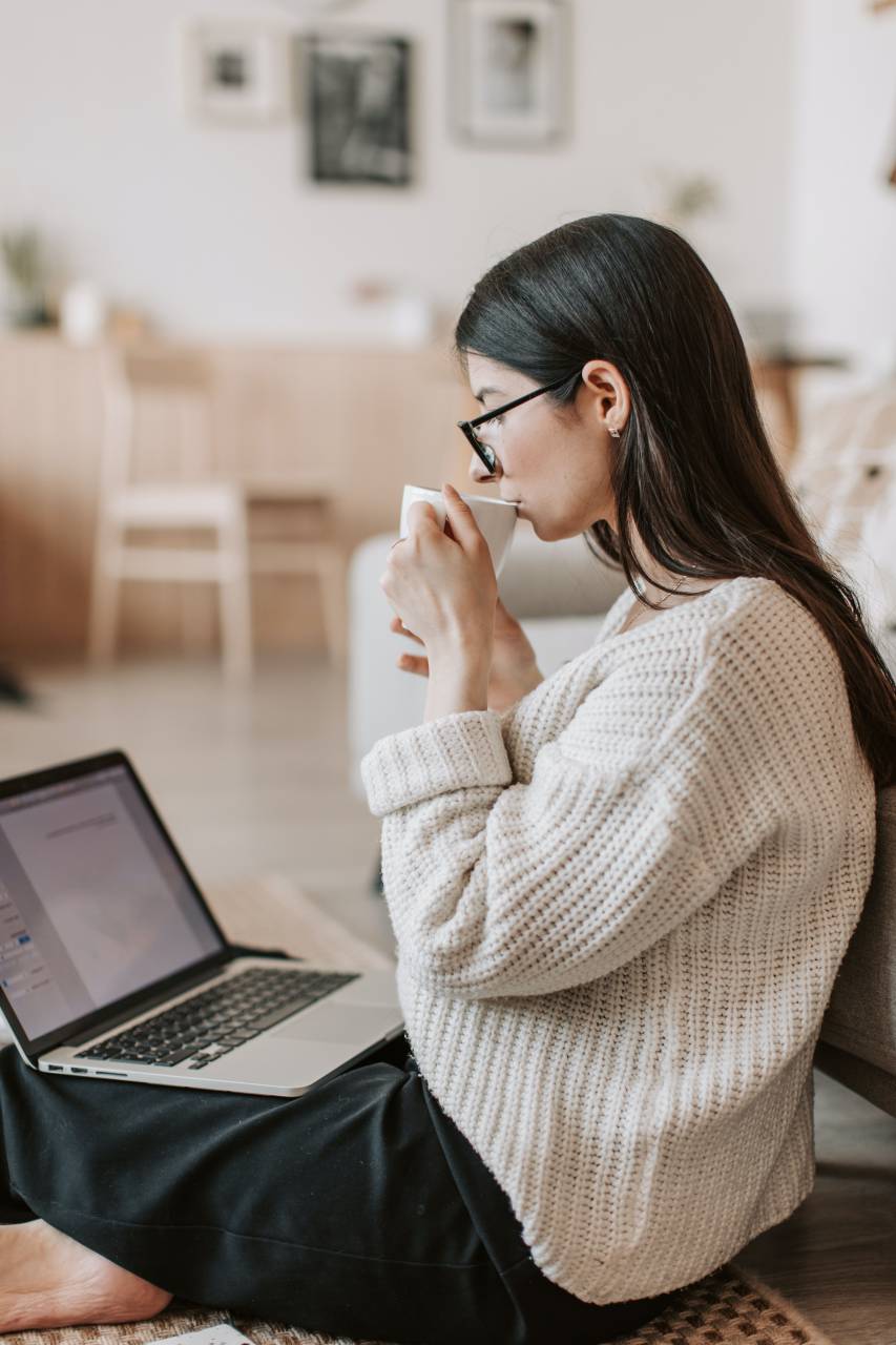 woman;Morning coffee;laptop,women,indoors,one person,lifestyles,adult,caucasian ethnicity,home interior,laptop,technology,young adult,sitting,casual clothing,females,relaxation,computer,working,brown hair,one,woman,looking,internet,domestic life,eyeglasses,young women,wireless technology,domestic room,living room,comfortable,leisure activity,smiling,sofa, 