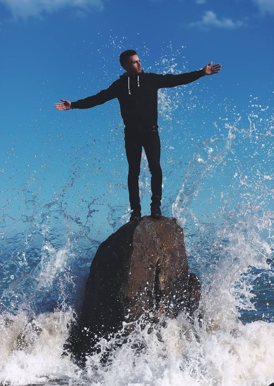 Chico, hombre, ola, agua, chapoteo, rock, formación, playa, mar, sudadera con capucha, cielo, negro, gente,