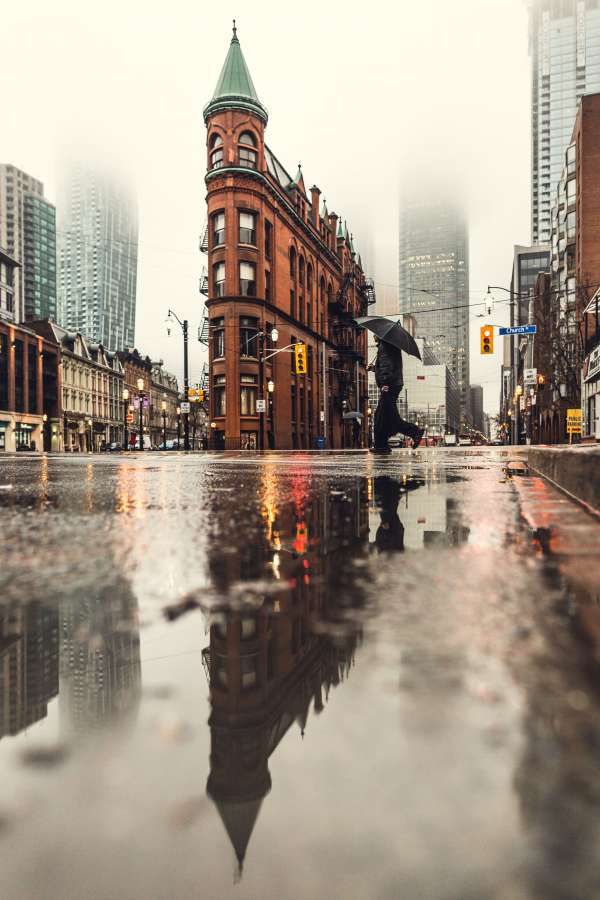 architecture, building, infrastructure, skyscraper, tower, city, urban, skyline, landmark, road, street, raining, water, reflection, people, walking, umbrella, traffic, light, pedestrian, crossing
, 