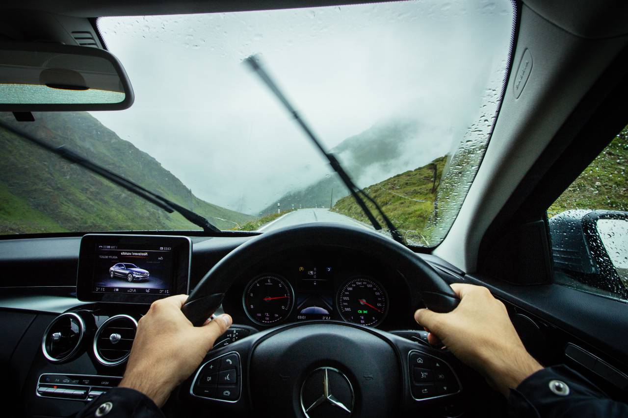 vehicle, car, inside, people, hands, driver, driving, travel, transportation, mercedes benz, outdoor, adventure, mountain, rain, wet, fog, sky, clouds
, 
