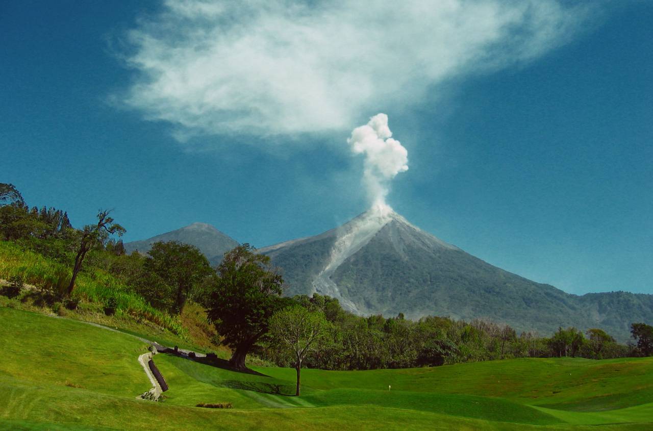 voclano, smoke, ash, mountain, golf course, fairway, green, hole, pin, trees, grass, outdoors, sky, blue
, 