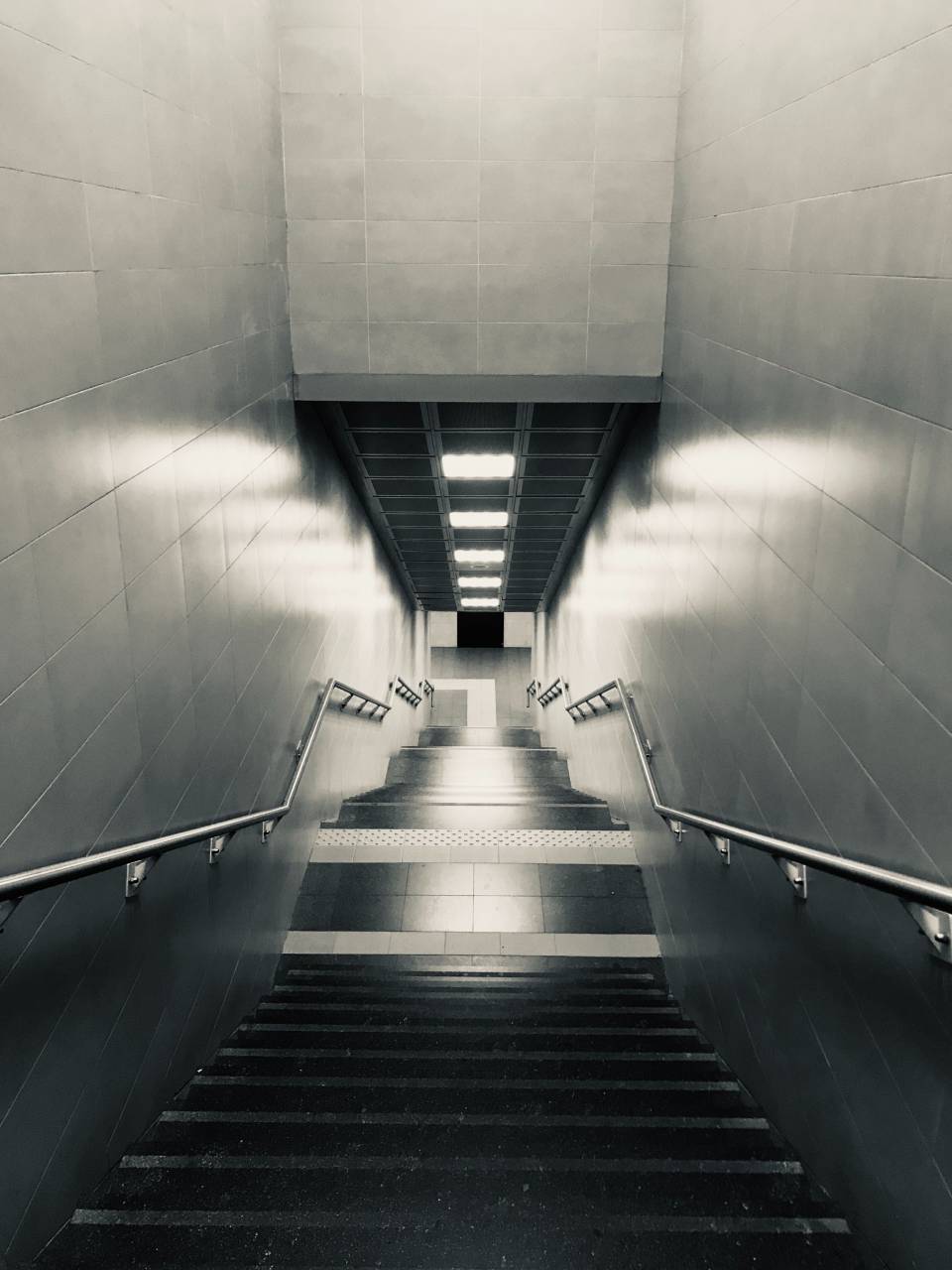 subway;staircase;Black And White,architecture,staircase,indoors,flooring,vanishing point,corridor,modern,subway station,steps,escalator,underground,entrance hall,built structure,diminishing perspective,futuristic,design,ceiling,wall,building feature, 