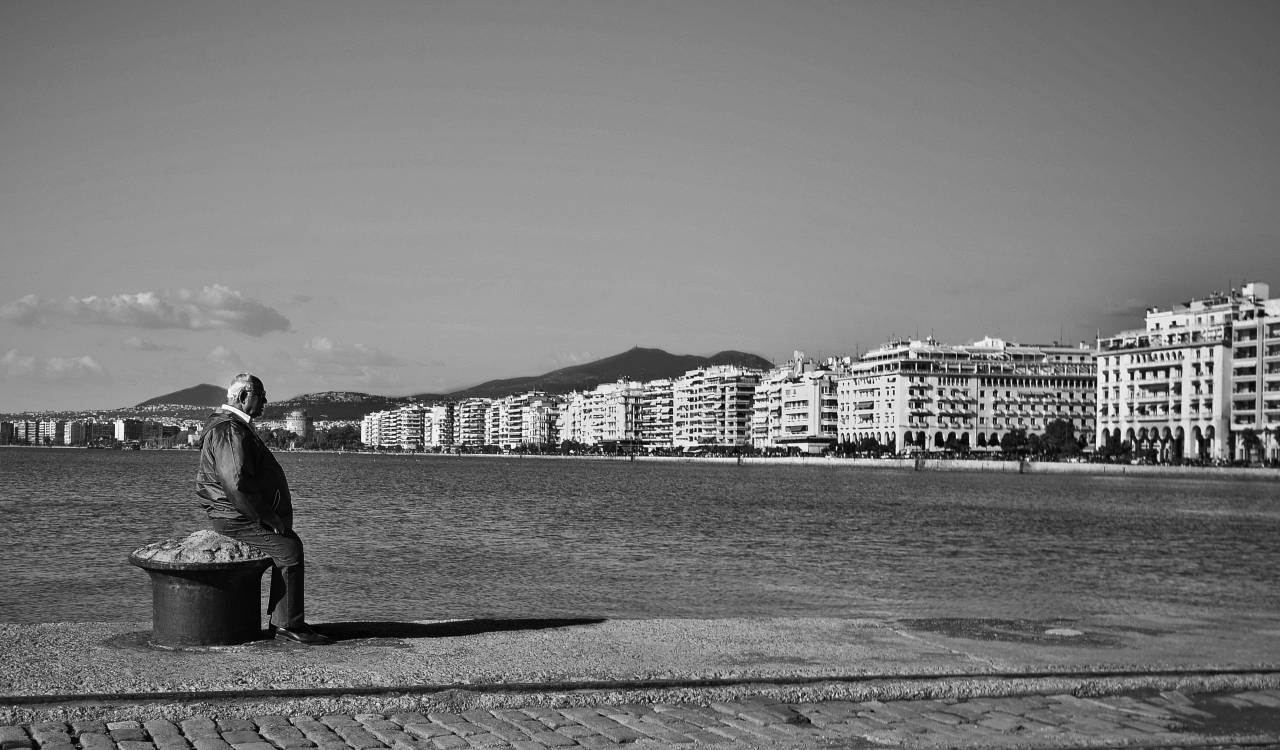 greece, buildings, boardwalk, cobblestone, bay, water, old, man, elderly, sitting, sky, city, town
, 