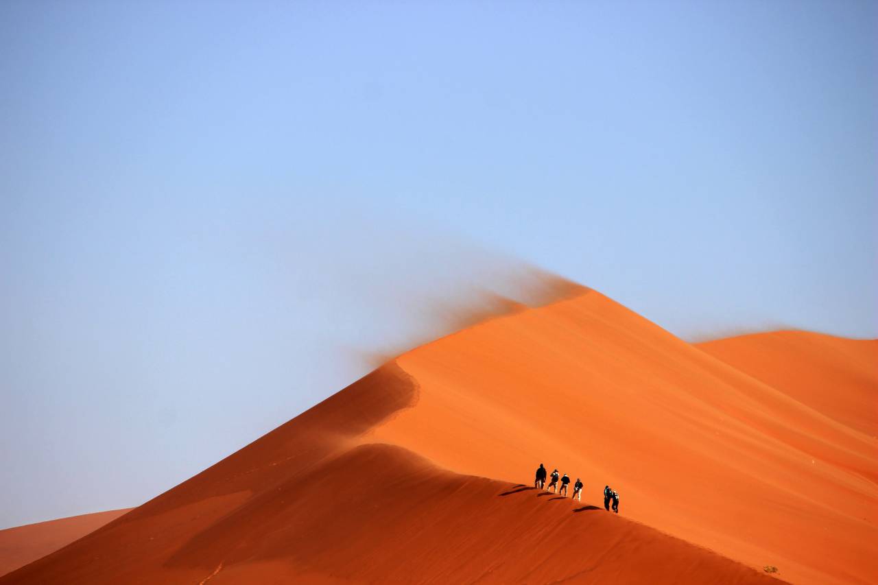 sand dunes, desert, hills, windy, hiking, hike, trek, people, blue, sky, orange, hot, sunny
, 