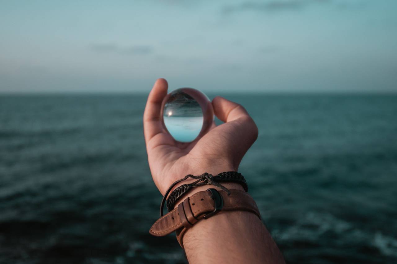 man, holding, glass, globe, watch, strap, hand, arm, sea, ocean, water, travel, cloudy
, 