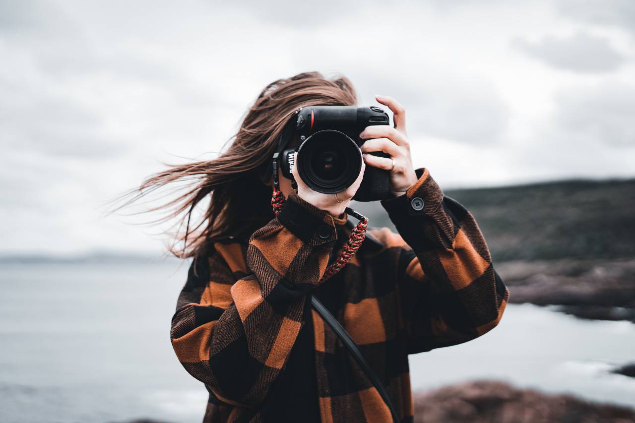 woman;photographer;camera;coast,outdoors,camera,photographic equipment,adult,one person,women,photographing,lifestyles,caucasian ethnicity,photographer,young adult,nature,looking,men,leisure activity,photography themes,hobbies,adventure,lens,optical instrument,holding,smiling,casual clothing,young women,females, 