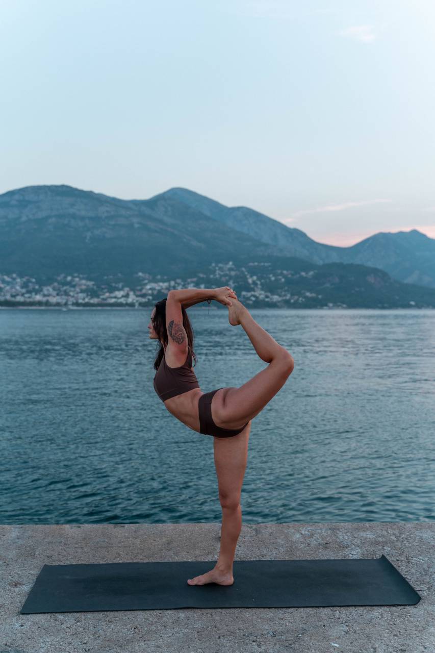 woman;yoga,yoga,women,exercising,sport,healthy lifestyle,outdoors,lifestyles,adult,one person,relaxation exercise,nature,stretching,caucasian ethnicity,relaxation,young adult,wellbeing,balance,gymnastics,water,summer,sports training,females,practicing,beauty, 