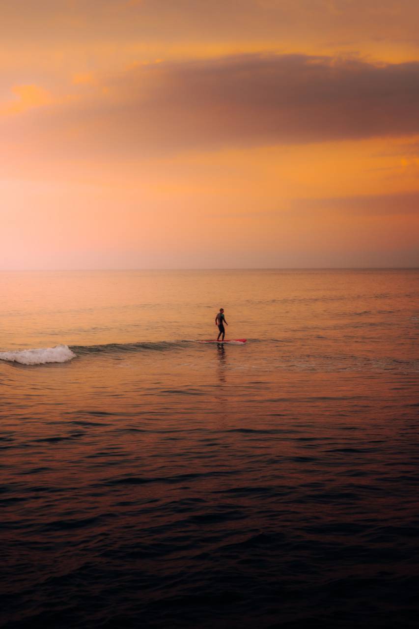 man;surf;sunset;calm,sunset,outdoors,nature,water,summer,silhouette,dusk,men,vacations,sun,women,sunlight,back lit,sunrise,dawn,one person,sport,adult, 