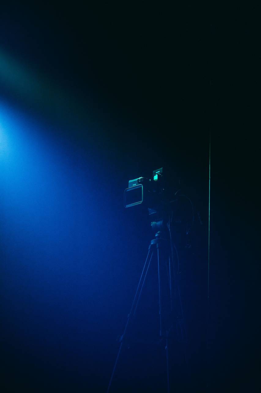 camera;blue;light,tripod,equipment,spotlight,stage,performance space,blue,night,lighting equipment,lens,optical instrument,dark,illuminated,camera,photographic equipment,performance,technology, 