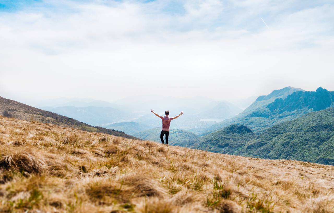 guy, man, male, people, back, stand, hands, raised, nature, landscape, mountains, summit, peaks, grass, lush, vegetation, trees, sky, clouds, trek, hike, climb
, 