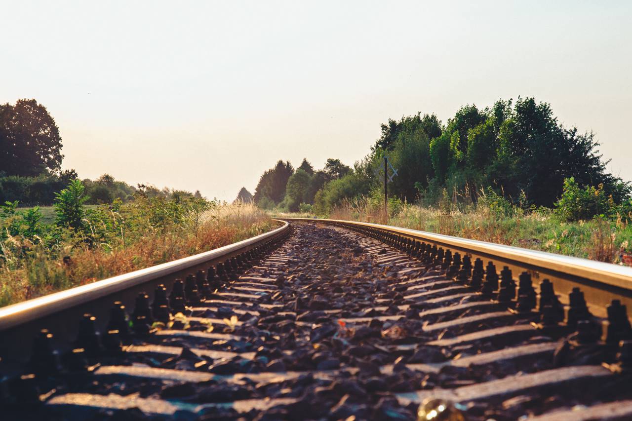 train tracks, railroad, railway, transportation, rocks, rural, countryside, grass, trees, nature, landscape, outdoors, sunshine, sky
, 