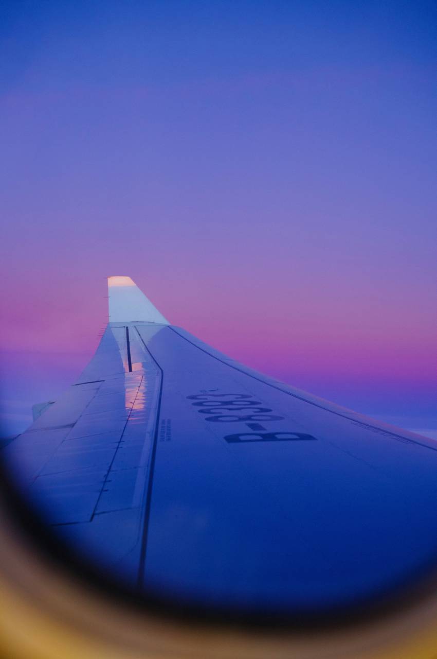 púrpura;avión;ala,avión,vehículo aéreo,puesta de sol,vuelo,azul,transporte,viajes,sol,avión comercial,al aire libre,anochecer,ala de avión,vacaciones, 
