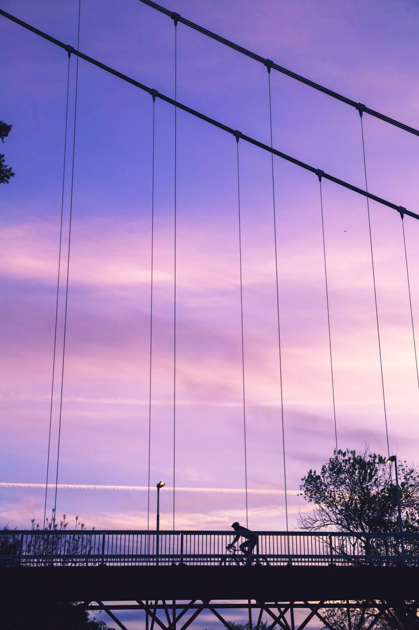purple;cyclist;bridge;sunset,sunset,silhouette,dusk,nature,back lit,outdoors,sun,sunlight,sunrise,dawn, 