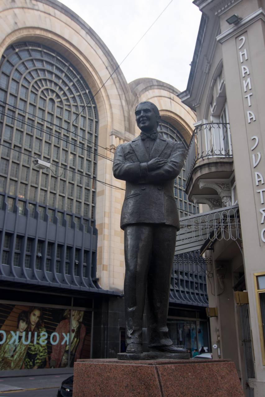 Carlos Gardel, Abasto Shopping, Buenos Aires, Argentina, Statue, Facade, Building, Architecture, Commercial, Retail, Shopping mall, Landmark, Tourist attraction, Urban, City, Street, Blue sky, Metal, Glass, Modern, Contemporary, Design, Exterior, Outdoor, Travel, Destination, Culture, Entertainment, Music, Tango, 