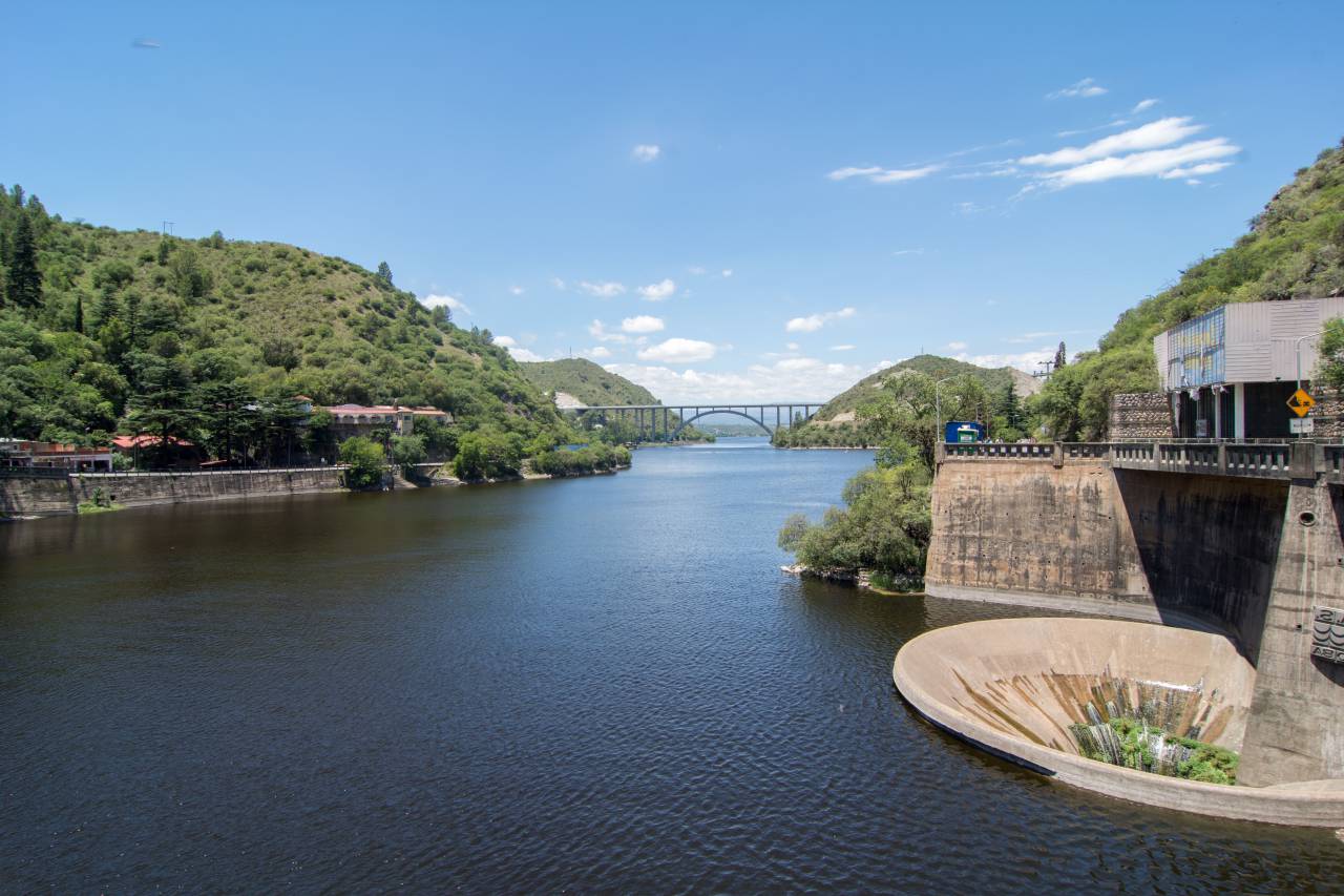 San Roque dam, water funnel, Villa Carlos Paz, Cordoba, Argentina, hydroelectric power, energy, reservoir, lake, infrastructure, engineering, technology, environment, tourism, travel, destination, landmark, scenic, panoramic, blue sky, clear water, mountains, reflection, peaceful, serene, tranquil, 