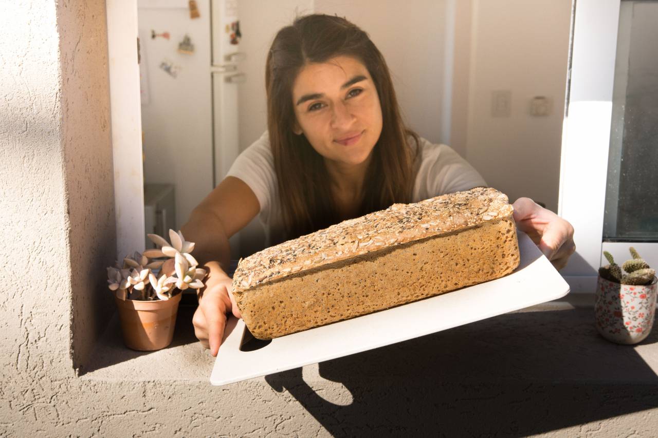 Woman, Showing, Bread, Homemade, Baked, Whole grain, Seed, Loaf, Food, Healthy, Delicious, Breakfast, Kitchen, Nutrition, Organic, Vegetarian, Crusty, Rustic, Homemade bread, Window, 
