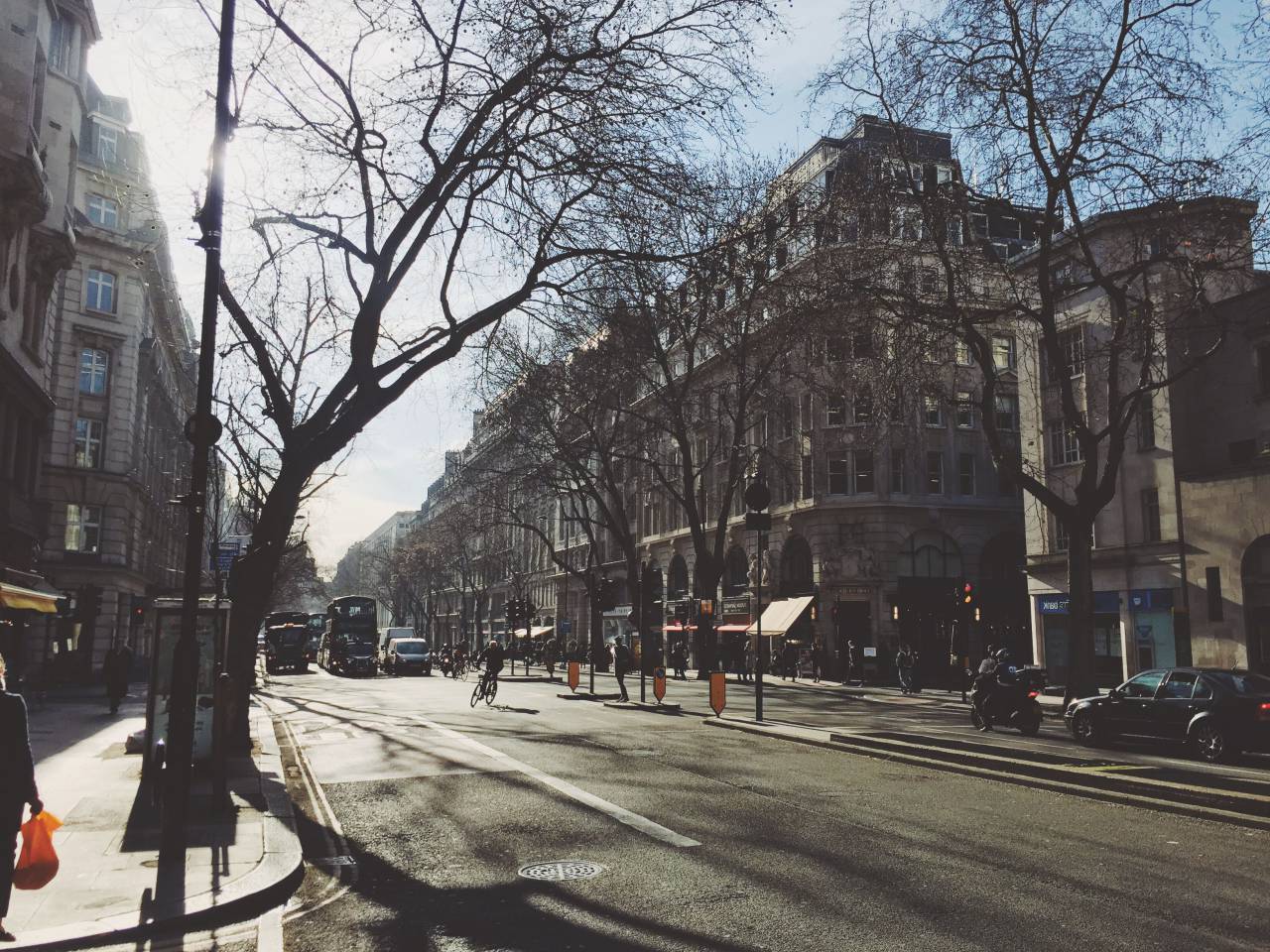 architecture, buildings, infrastructure, sky, tree, branches, street, road, car, vehicle, transportation, people, walking, city, urban, sunny, day
, 