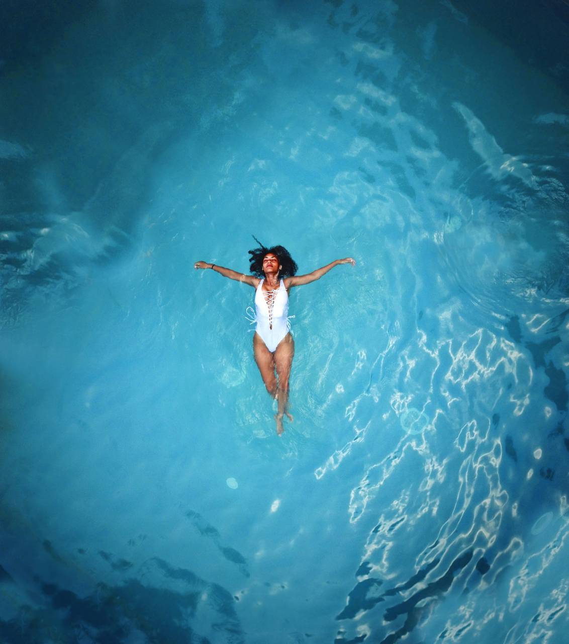woman, swimming, alone, isolated, pool, blue, white, swimsuit, dark, hair, travel, vacation, happy, chilled
, 