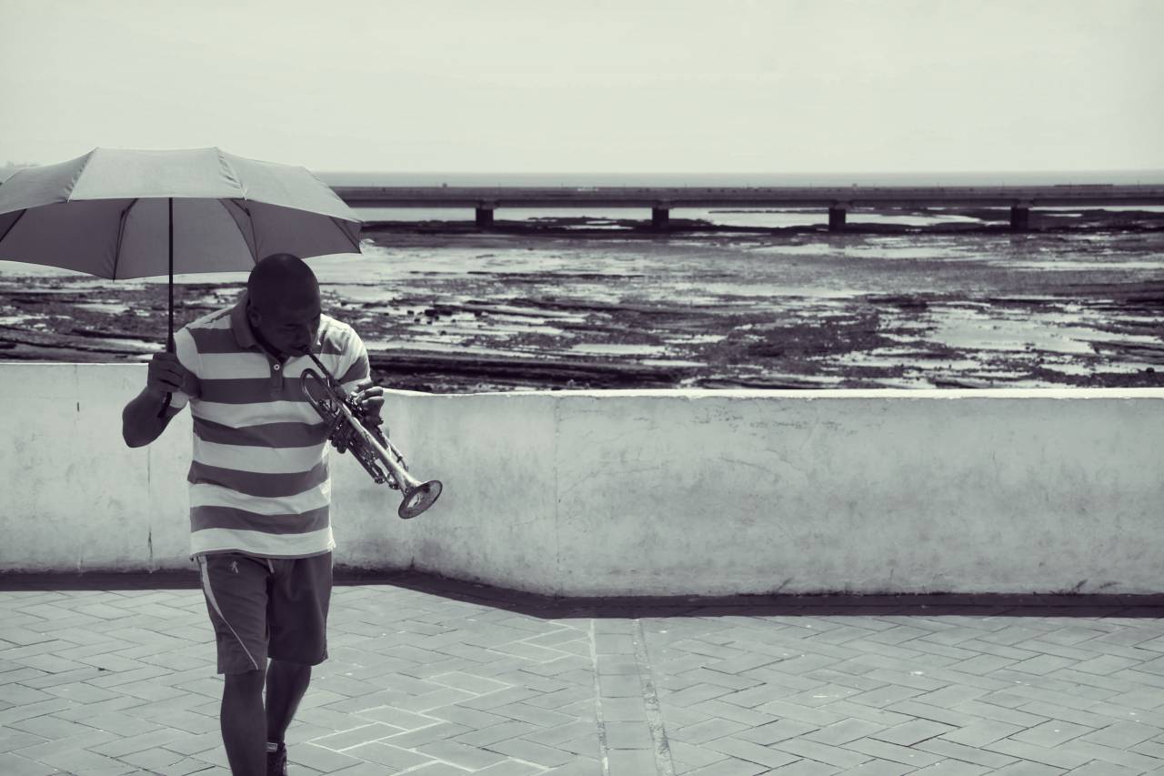 Panama, guy, man, people, trumpet, musician, music, umbrella, shorts, ocean, sea, water, black and white
, 