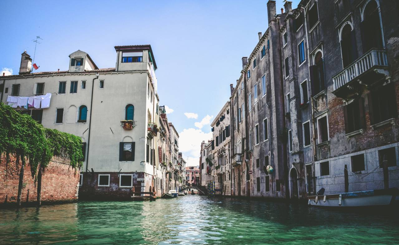 sky, clouds, building, structure, river, water, wall, boat, laundry, green, plants
, 