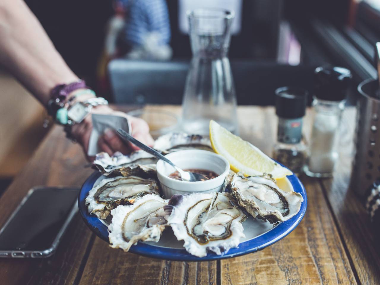 table, restaurant, bar, food, shell, seafood, raw, vinegar, sauce, lemon, hand, mobile, phone
, 