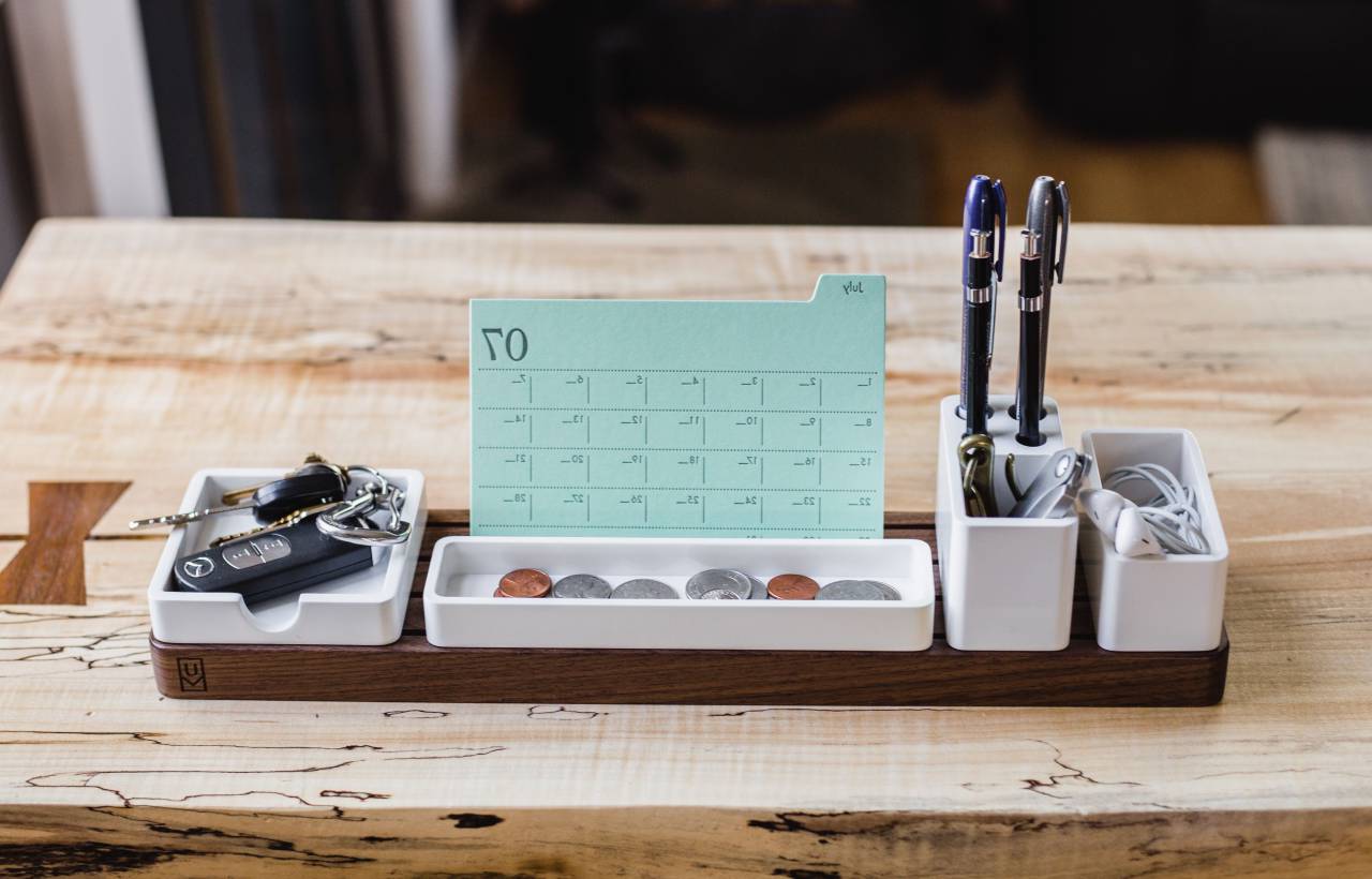 Calendario, pantalla, bolígrafos, llave, auriculares, monedas, accesorios, madera, mesa, interior