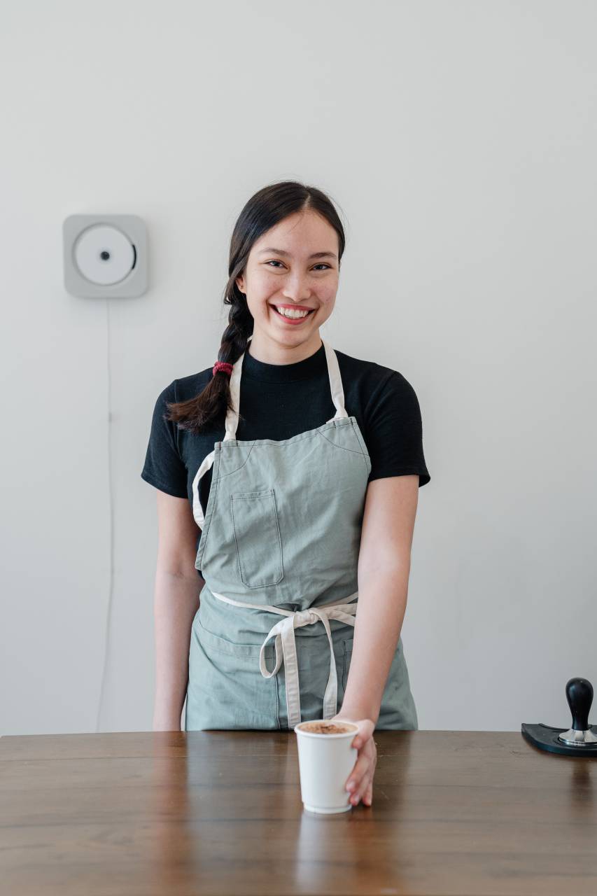 Asiática, Mujer, Sonriente, Sirviendo, Café, Cafetería, Barista, Hospitalidad, Amable, Servicio al cliente, Juvenil, Cálido, Bebida, Informal, Enérgico, 