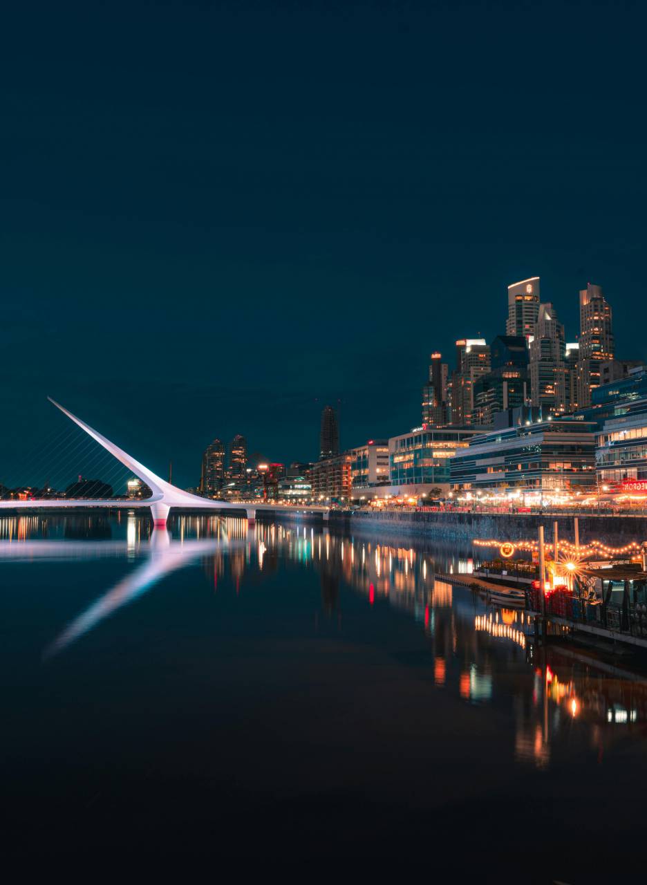 Puerto Madero, Woman Bridge, Buenos Aires night, cityscape at night, illuminated bridge, urban waterfront, Argentina nightlife, modern architecture, riverfront view, city lights, iconic landmark, night photography, urban skyline, river docks, Buenos Aires city, light reflections, pedestrian bridge, metropolitan area, night scene, travel destination, South America city, architectural lighting, evening cityscape, modern bridge, city river, tourist attraction, Buenos Aires landmarks, urban beauty, nighttime panorama, waterfront promenade, vibrant night view, latinamerican, 