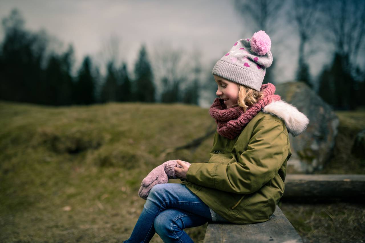 people, girl, teen, beanie, gloves, jacket, happy, smile, plants, grass, tree, pine, rock, sky, clouds, landscape, sitting, nature
, 