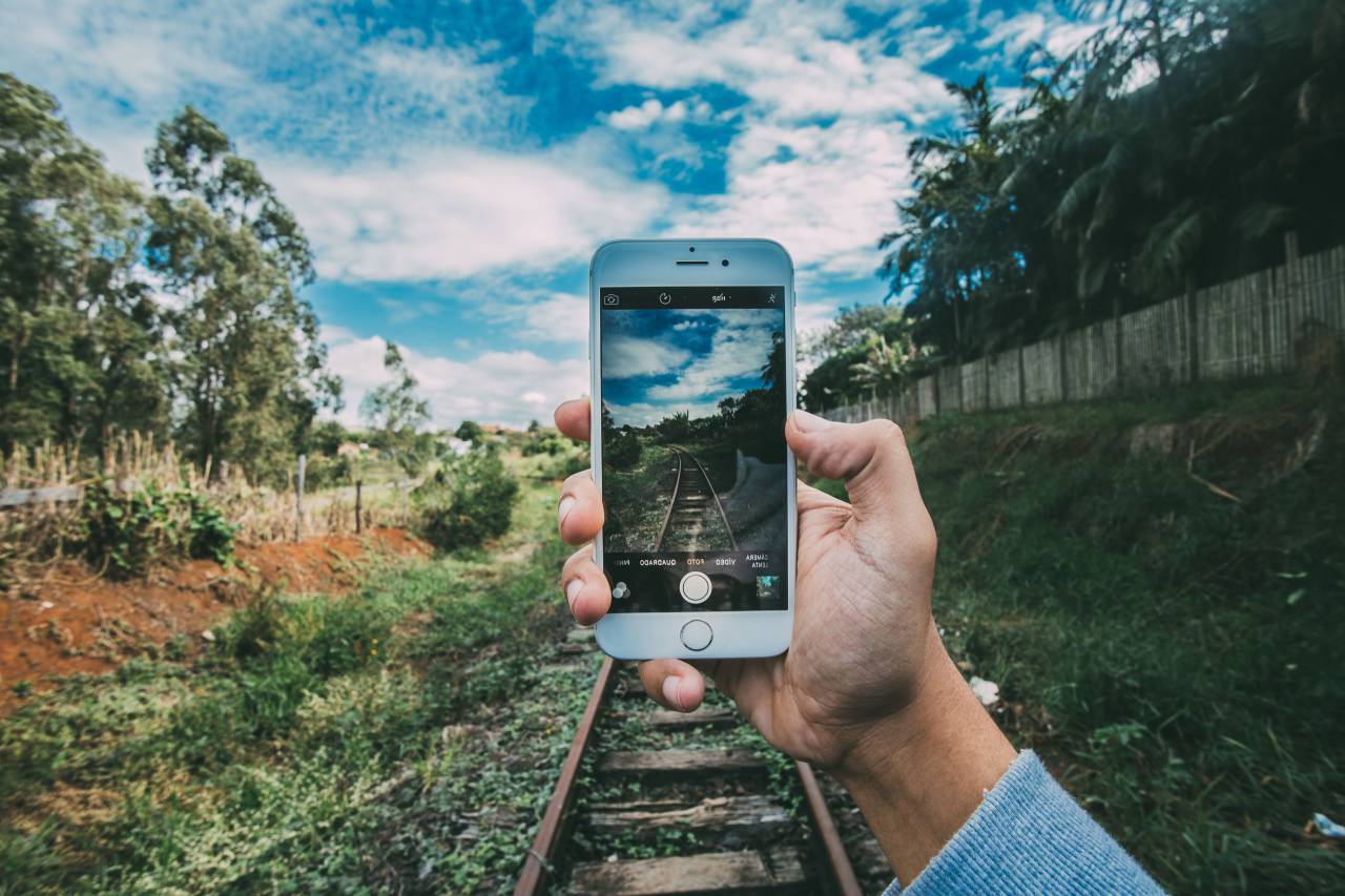 technology, gadgets, iphone, smartphone, mobile, nature, forests, trees, grass, train, rails, tracks, sky, clouds, horizon, guy, man, hands, hold, photography
, 