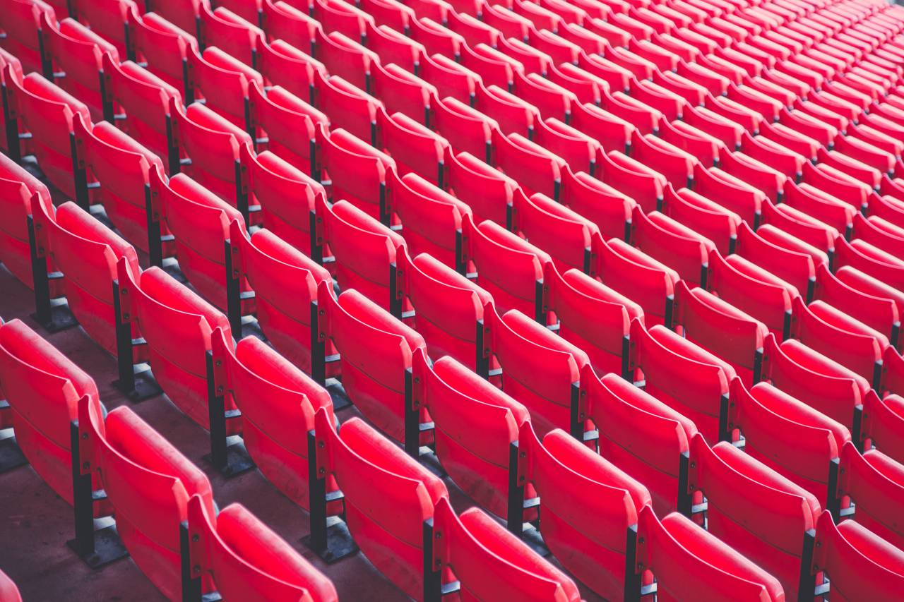 bleachers;stadium;red,seat,chair,in a row,auditorium,empty,sport,audience,stage theater,movie theater,presentation,convention center,sitting,performance,no people,stage,performance space,seminar, 