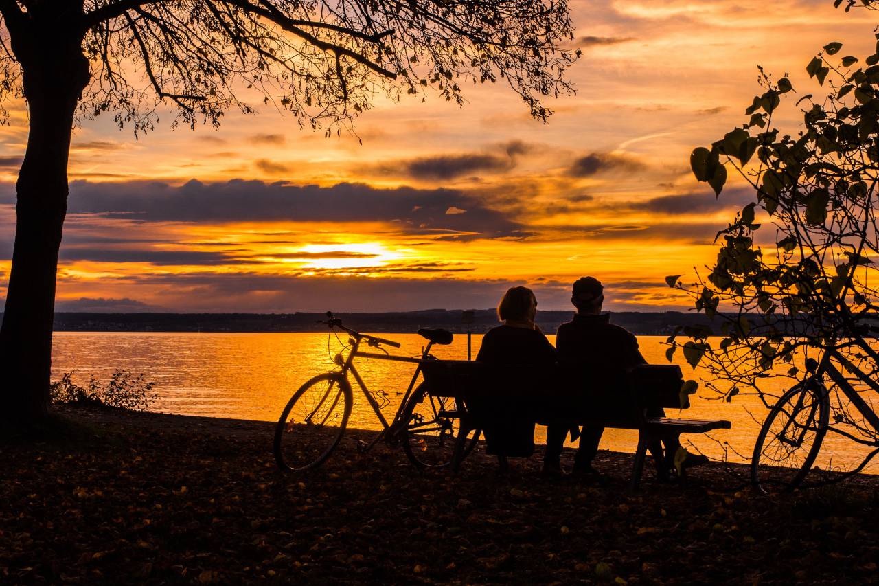couple;sunset;lake;bicycle;bench,sunset,outdoors,nature,men,women,sun,dusk,silhouette,summer,back lit,sunrise,dawn,relaxation,lifestyles,sunlight,leisure activity,vacations,recreational pursuit,tree,tranquil scene, 