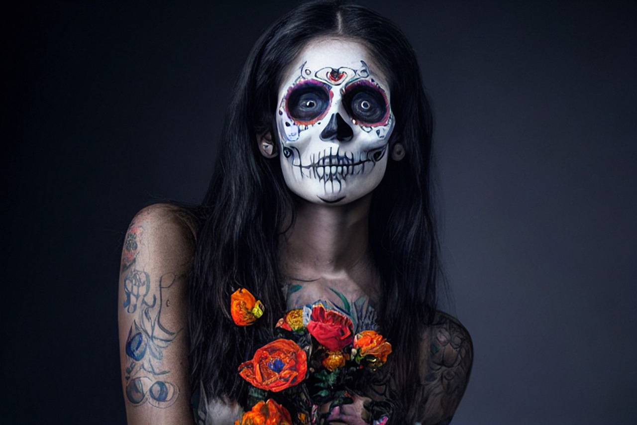 Day of the Dead;skull;painted face,women,one person,halloween,adult,caucasian ethnicity,portrait,celebration,black background,spooky,human face,young adult,looking at camera,studio shot,beauty,tattoo,flower,smiling, 